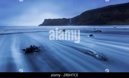 Lange Exposition am Talisker Beach in der blauen Dämmerung mit Blick auf die beeindruckenden Klippen auf der Isle of Skye, Schottland, Großbritannien Stockfoto