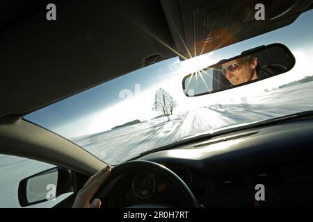 Mann ein Auto auf einer verschneiten Straße, Bayern, Deutschland Stockfoto