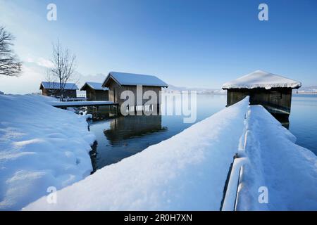 Verschneite Bootshäuser am See Kochel, Oberbayern, Deutschland Stockfoto