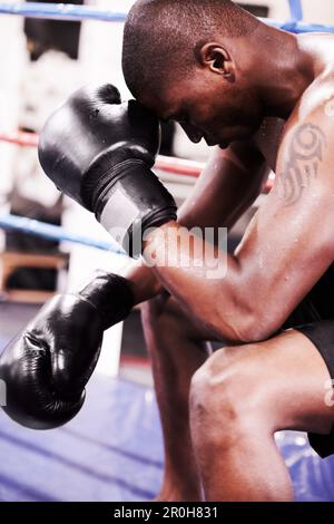 Niederlage ist nur vorübergehend. Ein Boxer, der sich einen Moment nach dem Kampf nimmt. Stockfoto