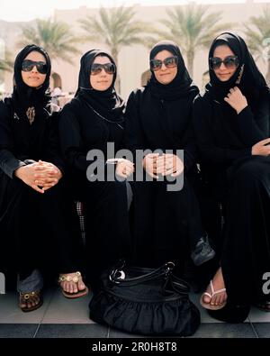 OMAN, muslimische Frauen sitzen Seite an Seite in traditioneller Kleidung im Barr Al Jissa Resort and Spa Stockfoto