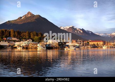 ALASKA, Sitka, ein friedlicher Blick auf Häuser und Fischerboote entlang der Küste im Hafen von Sitka bei Sonnenuntergang, Crescent Bay Stockfoto