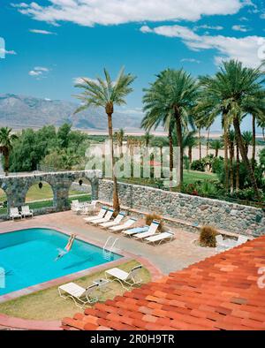 USA, Kalifornien, Death Valley, Frau Tauchen im Pool, Furnace Creek Inn Stockfoto