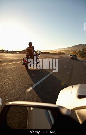 USA, California, Malibu, ein Paar auf einem Motorrad Kreuzfahrten entlang des Pacific Coast Highway am Ende des Tages