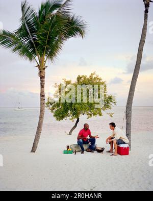 USA, Florida, Freunde im Gespräch grillen Fisch am Strand, Islamorada Stockfoto