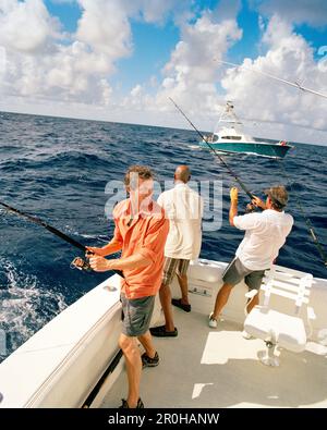 USA, Florida, drei Männer angeln auf der Rückseite eines Bootes, Islamorada Stockfoto