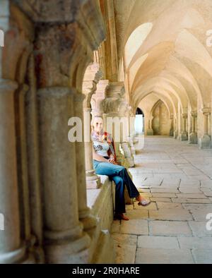 Frankreich, Burgund, junge Frau sitzt in der Abbaye de Fontenay, Marmagne Stockfoto