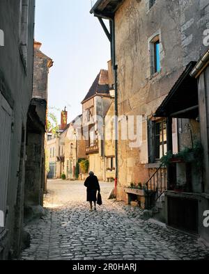 FRANKREICH, Burgund, Seniorin, die an Gebäuden vorbeiläuft, Rückansicht, Noyers Stockfoto