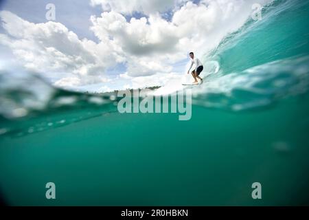 INDONESIEN, Mentawai-Inseln, Kandui Resort, junger Mann, der auf Wellen surft, Beng Beng Stockfoto