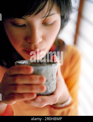 JAPAN, Kyushu, Nahaufnahme einer jungen Frau eine Holding Teetasse Stockfoto