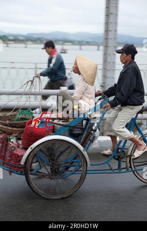 VIETNAM, Hue, ein Lebensmittel anbieter fahrräder seine Frau auf den Perfume River in den frühen Morgenstunden Stockfoto