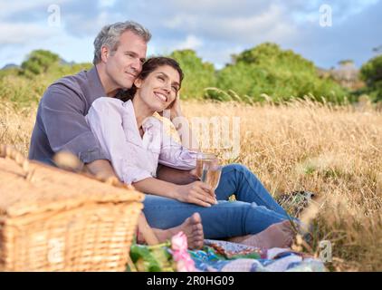 Nichts Romantischeres als ein Picknick. Ein liebevolles reifes Paar genießt ein intimes Picknick zusammen in einem malerischen Feld. Stockfoto