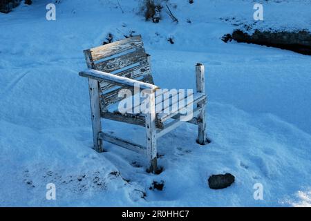 Verlassener alter Holzstuhl draußen in der Kälte Stockfoto