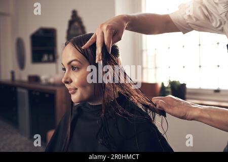 Glückliche Haare, glückliches Leben. Eine wunderschöne junge Frau, die sich im Salon frisiert. Stockfoto