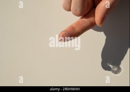 Nahaufnahme einer Kontaktlinse am Zeigefinger einer Frau. Stockfoto