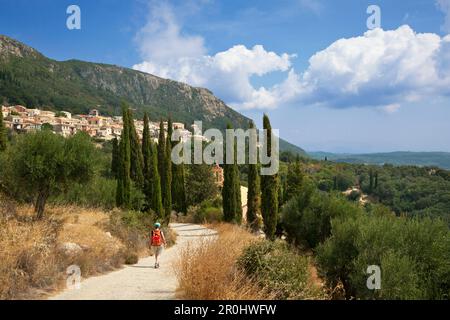 Frau wandert in Richtung Bergdorf Lakones, über Paleokastritsa, Insel Korfu, Ionische Inseln, Griechenland Stockfoto