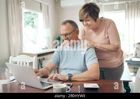 Du schaffst das, Schatz. Ein reifer Mann und eine Frau, die zusammen ein Notebook benutzen. Stockfoto