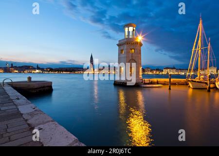 Kleiner Leuchtturm am Eingang zum Yachthafen auf der Insel Isola di San Giorgo Maggiore entlang Bacino di San Marco mit Blick auf Campanile Tower und Palaz Stockfoto