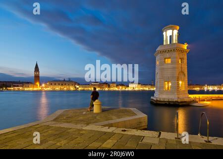 Kleiner Leuchtturm am Eingang zum Yachthafen auf der Insel Isola di San Giorgo Maggiore entlang Bacino di San Marco mit Blick auf Campanile Tower und Palaz Stockfoto