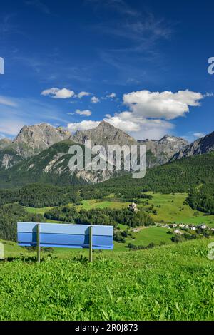 Blaue Bank mit Blick auf die Burg Tarasp und Sesvenna Range, Lower Engadin, Kanton Graubuenden, Schweiz Stockfoto