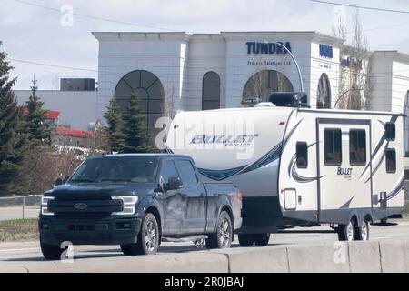 Calgary, Alberta, Kanada. 7. Mai 2023. Ein Pickup-Lkw mit Wohnmobil oder Wohnmobil-Anhänger auf der Route. Stockfoto