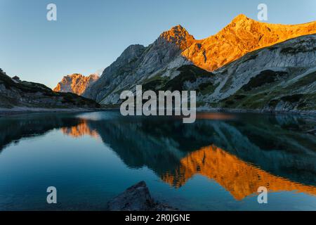 Drachensee mit Bergreflexion, Mieminger Berge, Wetterstein Berge mit Zugspitze bei Sonnenuntergang, Coburger Lodge, nahe Ehrwald, Bezirk Stockfoto