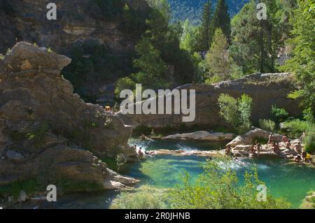 Menschen, die in felsigen Becken im oberen Fluss von Rio Borosa, Sierras de Cazorla, Segura y las Villas, Provinz Jaen, Andalusien, Spanien baden Stockfoto