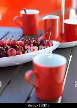 Rote Kirschen auf Porzellanteller, rote Becher, Mallorca, Spanien Stockfoto