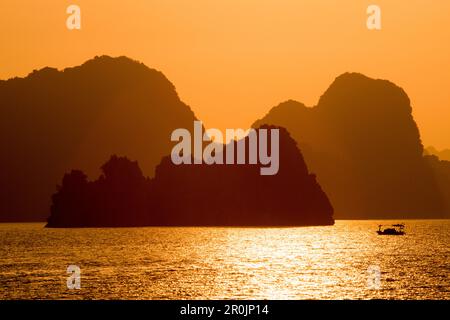 Fischerboot, Inseln und Berge der Ha Long Bay bei Sonnenuntergang, Ha Long Bay, Provinz Quang Ninh, Vietnam, Asien Stockfoto