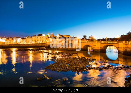 Blick über Rio Gilao in Richtung Altstadt und römische Brücke in der Abenddämmerung, Tavira, Algarve, Portugal Stockfoto