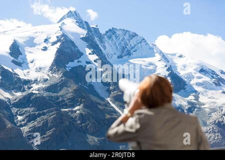 Eine Frau, die den Gipfel durch ein Teleskop betrachtet, Großglockner (3798 m), Franz-Joseph-High, Großglockner High Alpine Road, der höchste Berg in Nord Stockfoto