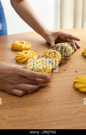 Auf dem Tisch köstliche Kekse dekoriert mit Dragees, süße Desserts im Studio, Tapete mit Gebäck, Komposition Stockfoto