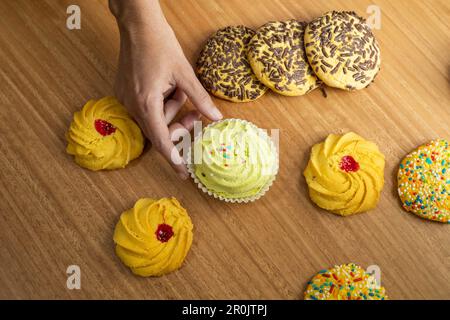 Konditorei, Bestellung köstlicher Kekse mit bunten Dragees, Desserts im Studio, süße Speisen mit detaillierten Texturen Stockfoto