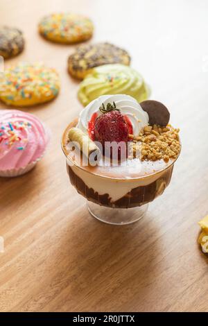 Köstliches Eis dekoriert mit Schokolade, Belag und Erdbeere im Hintergrund hausgemachte Kekse, Dessert als Tapete Stockfoto