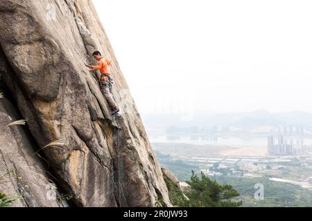Sportklettern in der Nähe von Xiamen, Klettern, junger Mann, Klettergebiet Nantaiwu, Granitfelsen, Xiamen, Fujian, China, Asien Stockfoto