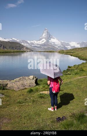 Ein taiwanesischer Besucher im Stellisee bei Zermatt mit Blick auf das Matterhorn, die Pennine Alps, den Kanton Valais, Schweiz Stockfoto