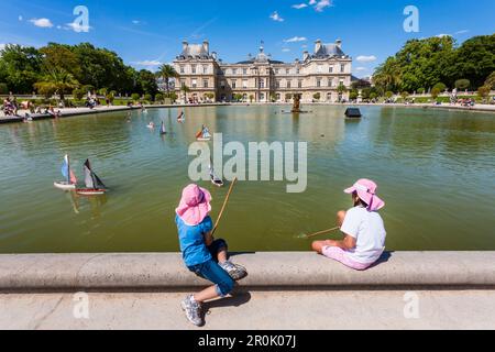 Mädchen spielen mit Segelschiffen am Teich des Palais du Luxembourg, Jardin du Luxembourg, 6. Arrondissement, Quartier Latin, Paris, Frankreich Stockfoto