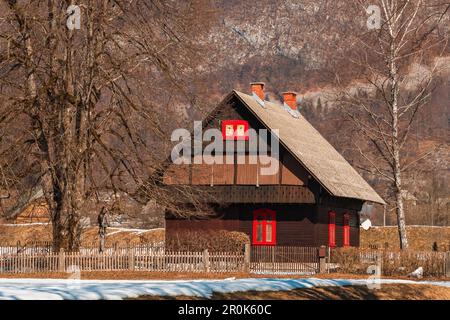 Traditionelles slowenisches hölzernes Gebirgshaus im Triglav-Nationalpark am sonnigen Wintertag Stockfoto