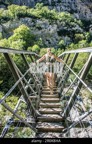 Brücke über den Fluss Verdon, Frau, die über eine Brücke geht, Provence-Alpes-Cote d'Azur, Lac de Sainte-Croix, Frankreich Stockfoto