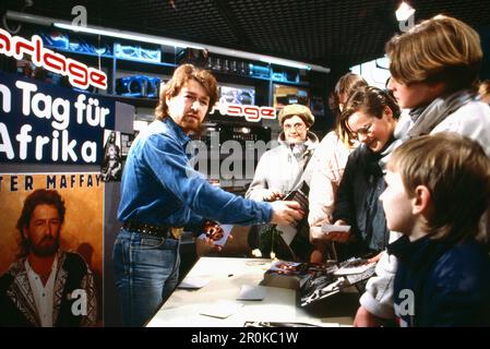 Peter Maffay, deutscher Sänger und Komponist, bei einer Autogrammstunde in einem Media-Geschäft in Bremen anlässlich der Aktion 'ein Tag für Afrika', Deutschland 1984. Stockfoto