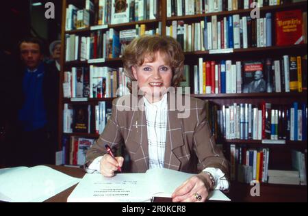 Hannelore Kohl, erste Ehefrau von Bundeskanzler Helmut Kohl, signiert bei der Präsentation ihr Kochbuch 'was Journalisten anrichten', Deutschland 1988. Stockfoto