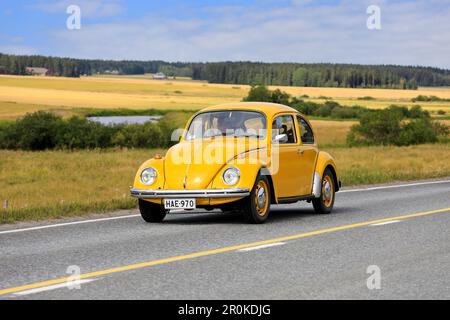 Gelber Volkswagen Käfer, offiziell Volkswagen Typ 1, fährt auf der Maisemaruise 2019-Autofahrt entlang der Landstraße. Vaulammi, Finnland. 3. August 2019. Stockfoto