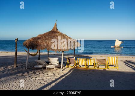 Ruhiger und schöner Tag am Anakao Beach in Madagaskar, mit einem klaren blauen Himmel, einer komfortablen Sonnenliege und einem farbenfrohen Sonnenschirm für Ihren ultimativen Stockfoto