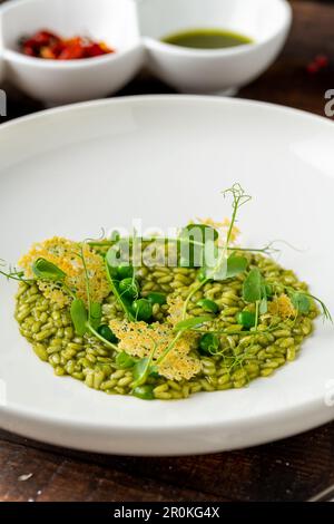 Erbsenrisotto auf weißem Porzellanteller in einem Feinschmeckerrestaurant Stockfoto