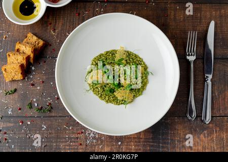 Erbsenrisotto auf weißem Porzellanteller in einem Feinschmeckerrestaurant Stockfoto