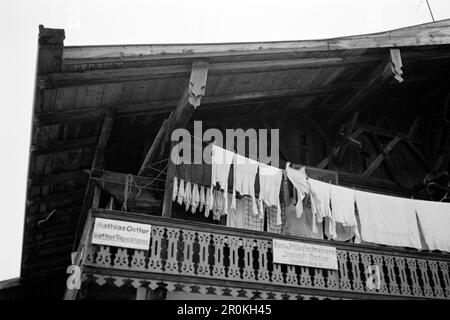 Eine Frau hängt Wäsche auf dem Balkon auf, Garmisch Partenkirchen 1936. Eine Frau legt die Wäsche auf den Balkon, Garmisch Partenkirchen 1936. Stockfoto