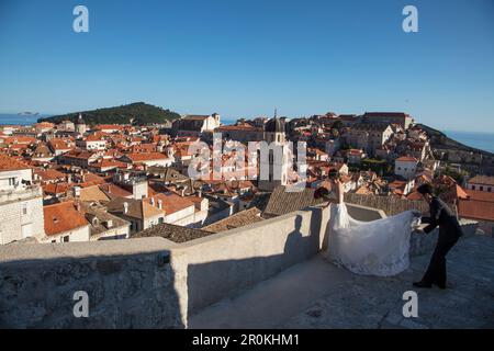 Asiatisches Hochzeitspaar posiert für Hochzeitsfotos an der Stadtmauer mit Blick auf die Altstadt von Dubrovnik, Dubrovnik, Dubrovnik-Neretva, Kroatien Stockfoto