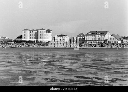 Das Watt bei Duhnen, Stadtteil von Cuxhaven, mit Blick auf die Strandpromenade und das ehemalige Kurhaus, später als Ove Ovens-Haus eine Jugendherberge, 1960. Die Schlammflächen in der Nähe von Duhnen, einem Stadtteil von Cuxhaven, mit Blick auf die Strandpromenade und das ehemalige Kurhaus, später ein Jugendherberge namens Ove Ovens-Haus, 1960. Stockfoto