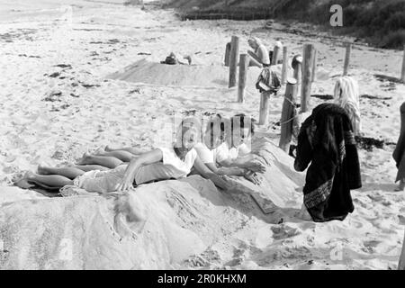 Frauen sonnen sich am Ostseestrand, 1966. Frauen, die sich an einem Ostseestrand sonnen, 1966. Stockfoto