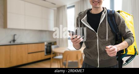 Der Zusteller hält einen Thermosack-Rucksack mit Lebensmitteln als Kurier Stockfoto